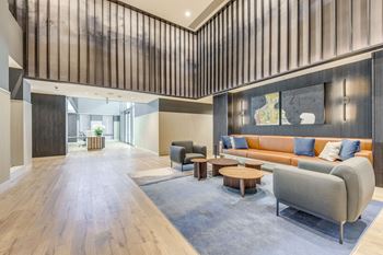 A modern living room with a grey sofa and wooden floors.